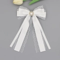 Detailed view of white lace ribbon hair clip with pearl and rhinestone centerpiece - White