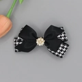 Detalle de elegante pinza para el pelo con lazo de pata de gallo, satén, perla y strass - Negro