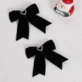 Détail de deux nœuds en velours noir avec des centres en strass en forme de cœur brillant - Noir