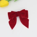 Detalle de un lazo de pelo de terciopelo rojo oscuro con colas largas y textura elegante - Rojo