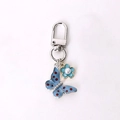 Silver butterfly keychain with blue enamel wings and small flower charm for bags - Blue Dotted Butterfly