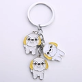Detailed view of silver keychain featuring three cute enamel white and yellow dog charms - Shih Tzu