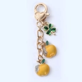 Cute golden heart keychain with two yellow apples, a green clover and small crystals - Yellow Apple Cluster