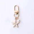 Pale gold starfish keychain featuring a white textured charm and faux pearl bead - White Starfish & Artificial Pearl Style (Starfish & Butterfly)