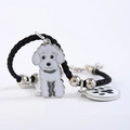 Detail van zwarte gevlochten huisdierarmband met wit hondje en pootafdruk hanger - Witte Teddy