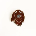Gros plan détaillé d'une broche en émail en forme de carlin aux textures brun foncé - Style Cocker Spaniel