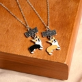 Détail des colliers Best Friend avec pendentifs Corgi mignons sur un support en bois - Corgi Noir et Jaune