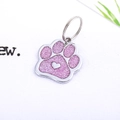 Detail of paw-shaped pet ID tag with pink glitter inlay and silver heart motif - Light Pink