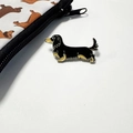 Broche en émail représentant un teckel à poil long noir et marron sur fond blanc - Teckel Noir Long