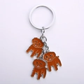 Metal keychain featuring three brown curly poodle charms with silver drip oil finish - Teddy Bear Charm Strand