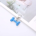 Dettaglio di un ciondolo a forma di osso in smalto blu a pois bianchi con chiusura a moschettone - Blu