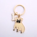 Goldener Schlüsselanhänger mit beigem Mops-Anhänger und kleinem weißen Knochen - Gold