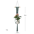 Detail of dark green macrame plant hanger with wooden bar measuring 80cm by 20cm - Style B / Dark Green