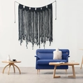 Handmade black woven bohemian wall hanging with tassels displayed above a blue sofa - Black (z007) / 85x100cm