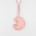Detailansicht der rosa Leder-Croissant-Schlüsselanhänger mit feiner Naht auf Weiß - Rosa