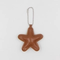 Detail view of a star-shaped tan faux leather keychain with silver bead chain and stitching - Coffee