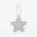 Detail of grey star-shaped PU leather keychain with silver bead chain and grey stitching - Gray