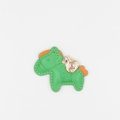 Close-up of green leather horse charm with gold money bag detail and orange accents - Green