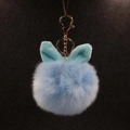 Détail du pompon en peluche bleu clair avec oreilles de lapin et fermoir doré en métal - Bleu