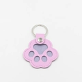 Close-up of a pink leather cat paw keychain with silver metal ring and stitch detailing - Light Purple