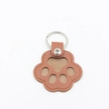 Brown leather cat paw keychain pendant with silver metal ring on a white background - Coffee