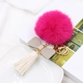 Detail van roze pompon sleutelhanger met grijze strik, witte kwast en gouden sluiting - Grijze Strik Witte Kwast
