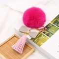 Detail van rozerode imitatiebont pompon sleutelhanger met leren strik en roze kwast - Grijze Strik Roze Kwast