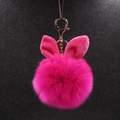 Détail du porte-clés pompon rouge rose avec oreilles de lapin et fermoir doré chic - Rouge Rose