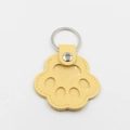 Detalle de llavero de pata de gato en cuero amarillo con ventana y anillo plateado - Amarillo