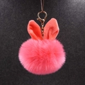 Porte-clés oreilles de lapin en peluche rose avec fermoir doré sur fond sombre - Rouge pastèque