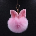 Gros plan du porte-clés pompon rose duveteux avec oreilles de lapin et fermoir doré - Rose Clair