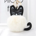 Cute black and white plush cat keychain with soft faux fur ball and golden hardware - Off White