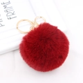 Detail of a dark red faux fur pompom keychain with golden metal ring and lobster clasp - Burgundy