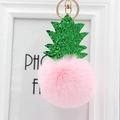 Détail du porte-clés ananas en fausse fourrure rose avec feuilles pailletées et anneau doré - Rose Clair