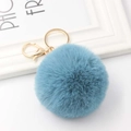 Close-up of blue fluffy faux fur pompom keychain with golden metal lobster clasp - Lake Blue