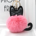 Close-up of fluffy pink pom pom keychain with black cat leather details and gold hardware - Deep Pink