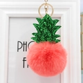 Vue détaillée du porte-clés peluche ananas rose avec paillettes vertes et anneau doré - Orange