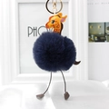Close-up of giraffe plush keychain with navy blue faux fur pompom and golden metal ring - Navy Blue