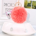 Detail of coral pink plush unicorn puff ball keychain with holographic wings and gold ring - Orange Red