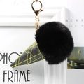 Close-up of black faux fur ice cream cone keychain with gold metal clasp and yellow stitching - Black
