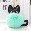 Close-up of fluffy green pompom cat keychain with black ears and golden metal clasp - Light Green