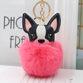 Dettaglio di un portachiavi a forma di cane con pompon rosa e anello in metallo dorato - Rosso anguria