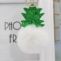 Détail du porte-clés ananas avec feuilles à paillettes vertes et pompon en fourrure blanche - Blanc