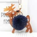 Detailed close-up of reindeer bag charm with navy faux fur pompom and golden antlers - Navy Blue