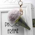 Detail of grey fur ball ice cream keychain with black leather cone and gold metal clasp - Light Gray