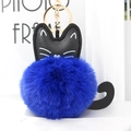 Detail of cute cat plush keychain with a dark blue fluffy pom-pom and golden metal ring - Sapphire Blue