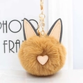 Gros plan d'un porte-clés chat en peluche marron avec cœur rose et chaîne dorée - Café