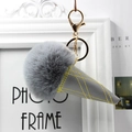Detail view of ice cream keychain showing gray faux fur pompom and quilted cone texture - Medium Grey