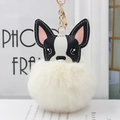Dettaglio del ciondolo a forma di cane con pompon bianco crema e portachiavi d'oro - Bianco avorio