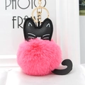 Close-up of pink fluffy plush cat keychain with black leather ears and gold lobster clasp - Watermelon red